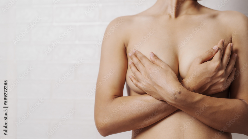 Fototapeta premium Young asian woman examining breast mastopathy or signs of breast cancer, Closeup Sexy Topless Naked Female With Breast Cancer Awareness