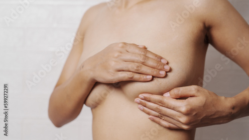 Young asian woman examining breast mastopathy or signs of breast cancer, Closeup Sexy Topless Naked Female With Breast Cancer Awareness