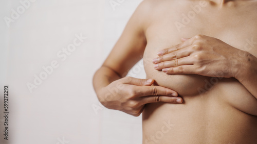 Canvas Print Young asian woman examining breast mastopathy or signs of breast cancer, Closeup