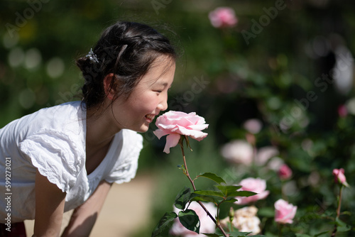 薔薇の香りを嗅ぐ少女
