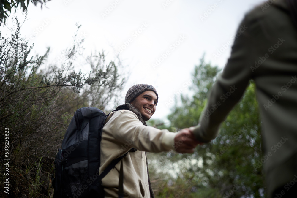 Hiking hand in hand. a young couple hiking hand in hand in the great outdoors.