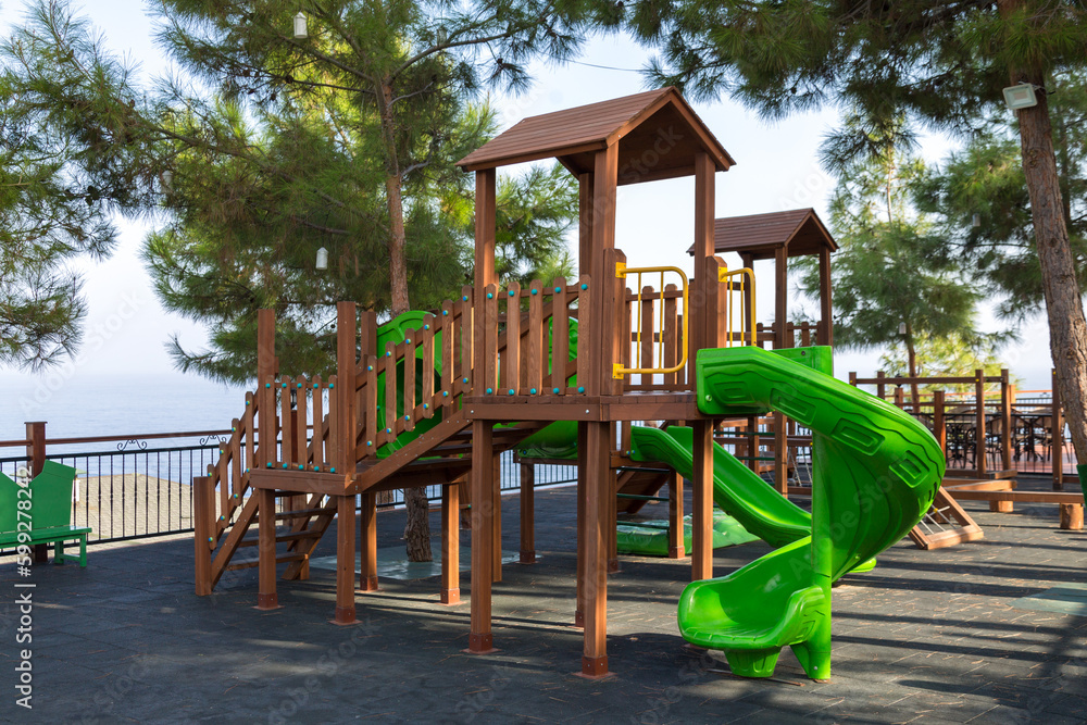 Wooden children's house with a slide playground. Wooden children's house with a slide playground.