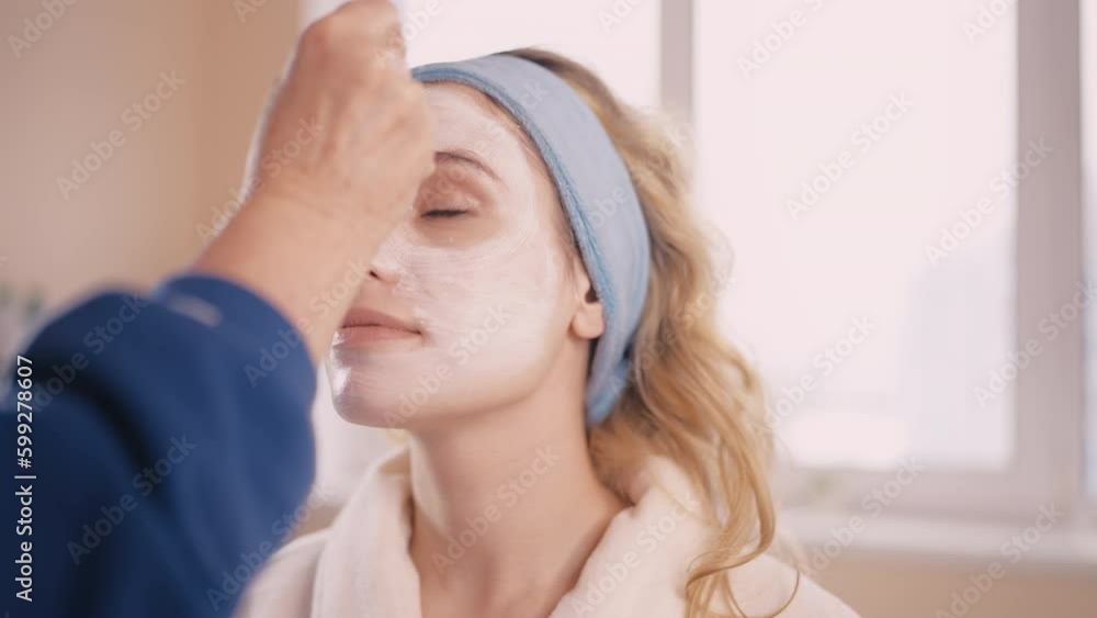 Young woman getting professional facial, acne treatment in beauty salon Young woman getting professional facial, acne treatment in beauty salon