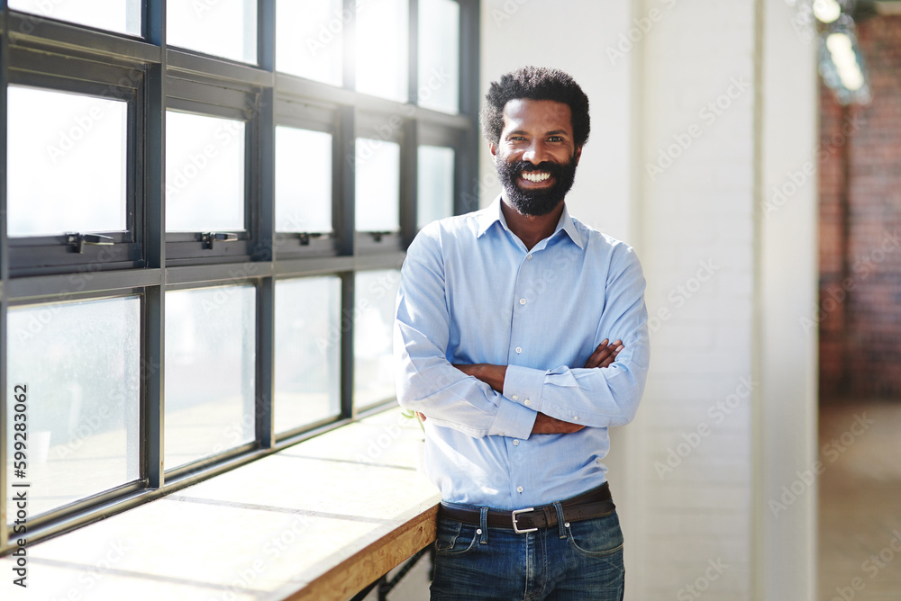 This smile is a mark of my success. Cropped portrait of a confident businessman standing at a window in an office. This smile is a mark of my success. Cropped portrait of a confident businessman standing at a window in an office.