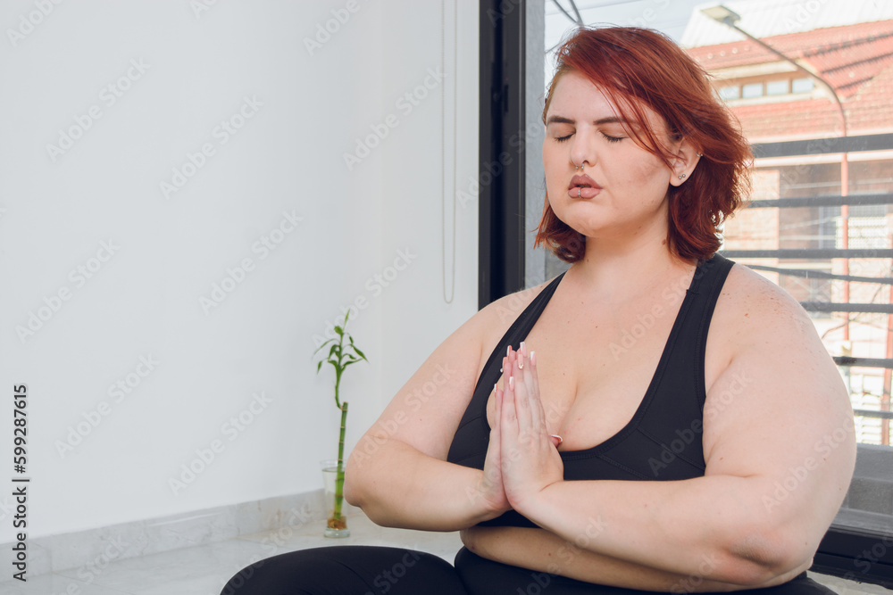 young plus size argentinian latina woman with eyes closed and hands in anjali mudra position young plus size argentinian latina woman with eyes closed and hands in anjali mudra position