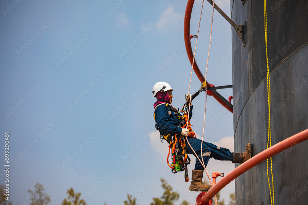 Focus male swing rope worker down height tank roof rope access safety inspection of thickness storage tank