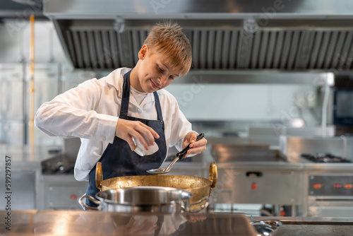 Foto Happy student boy learning cooking food in class at school kitchen