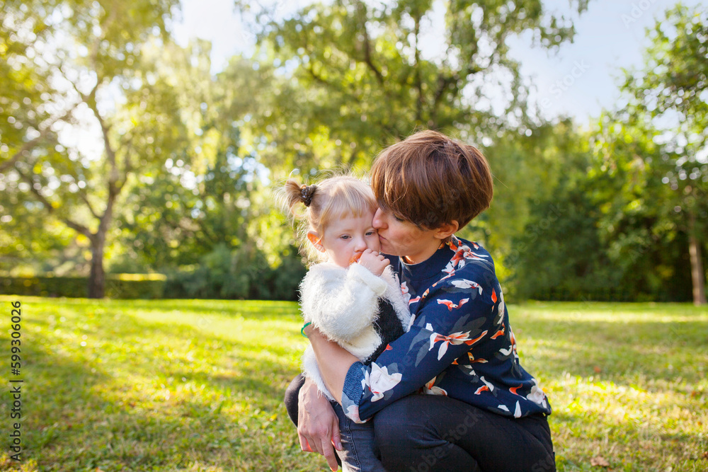 Mother kissing daughter (2-3) in park Mother kissing daughter (2-3) in park
