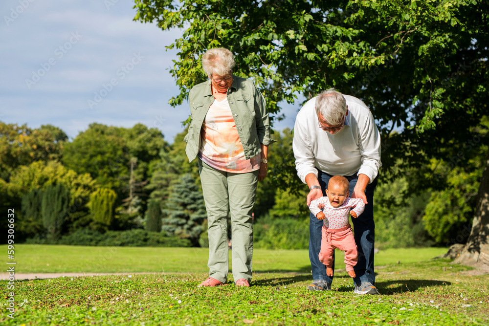 Grandparents with granddaughter (6-11 months) in park Grandparents with granddaughter (6-11 months) in park