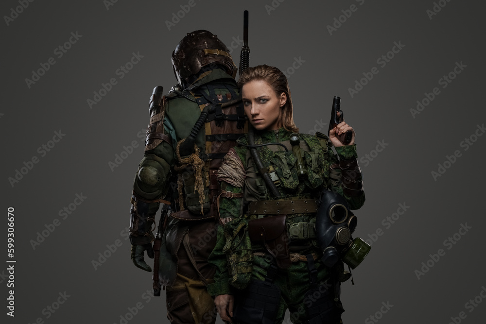 Photo of isolated on grey two female and male soldiers posing back to back.