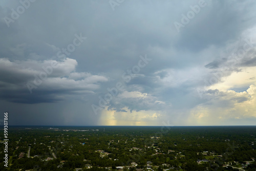 Dark stormy clouds forming on gloomy sky during heavy rainfall season over suburban town area