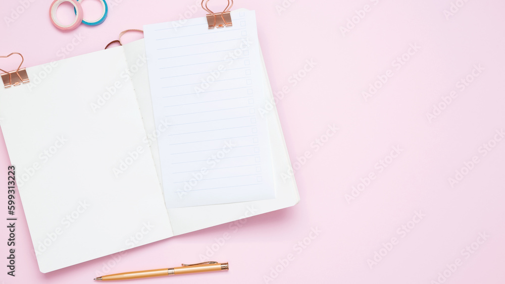 Creative flat lay mockup design of workspace. Top view composition with white notebook, to do list and stationery on pink background Creative flat lay mockup design of workspace. Top view composition with white notebook, to do list and stationery on pink background