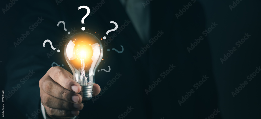 Glowing lightbulb and question mark with copy space. Businessman ...