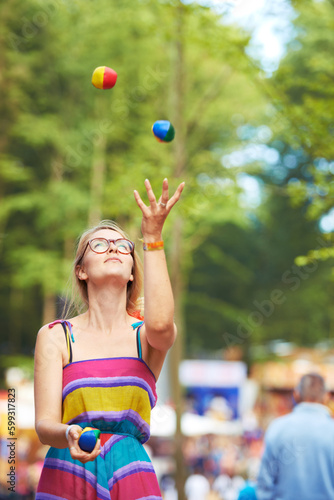 Shes a great juggler. an attractive young woman juggling at an outdoor festival.
