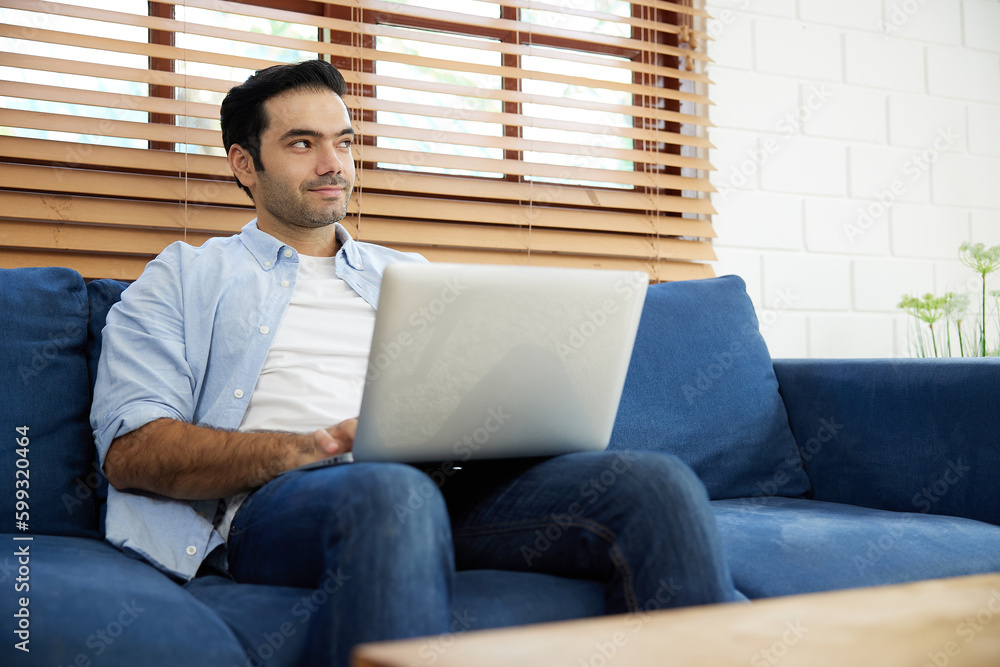 young handsome man using laptop computer for work at home young handsome man using laptop computer for work at home