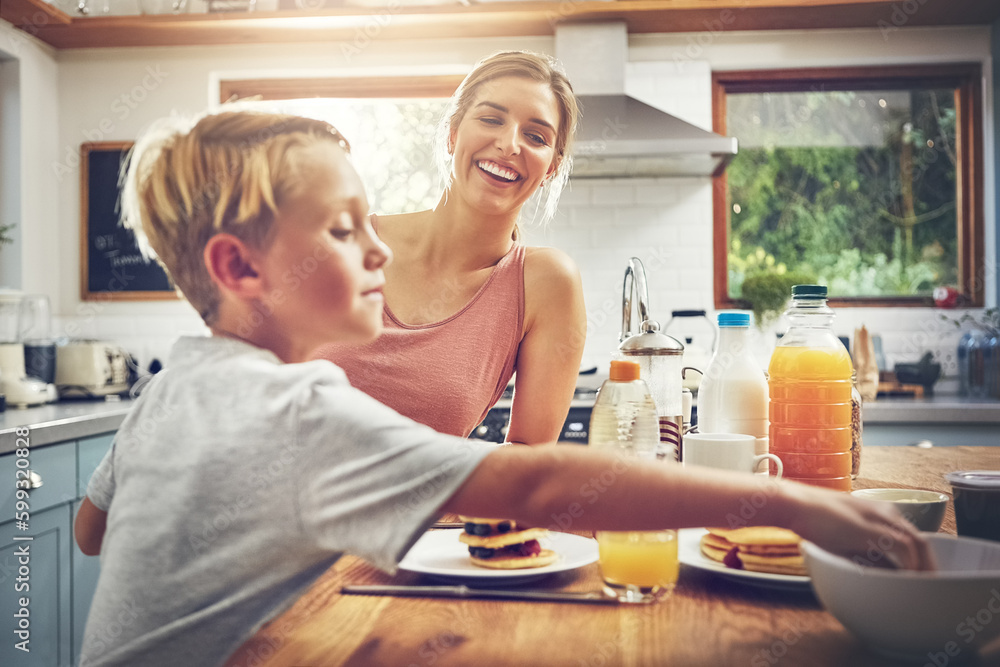 It makes me happy when he eats like this. a woman sitting with her son while hes having breakfast. It makes me happy when he eats like this. a woman sitting with her son while hes having breakfast.
