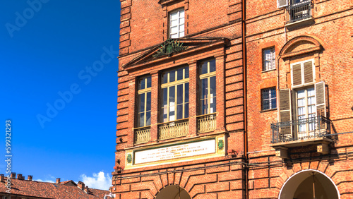 
window of the Palazzo della Prefettura near Piazza Castello crowded with people on a sunny spring afternoon