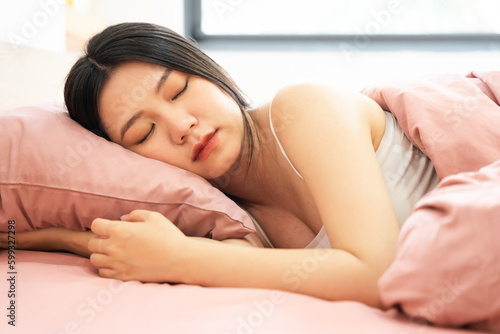 Portrait of a beautiful and playful asian girl in bed in the morning