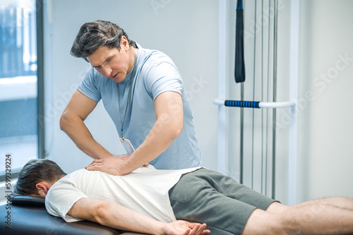 Male patient having a session of rehabilitation back massage © zinkevych