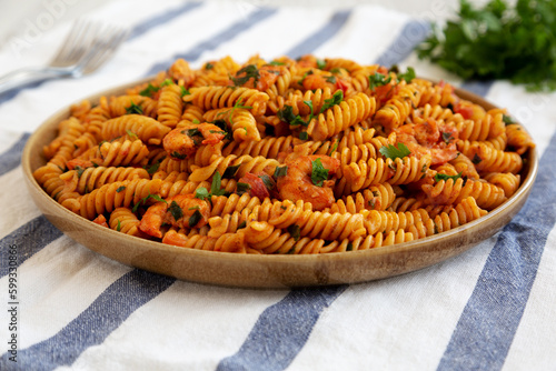 Homemade Creamy Tomato Shrimp Rotini Pasta with Parsley on a Plate, low angle view. Close-up.