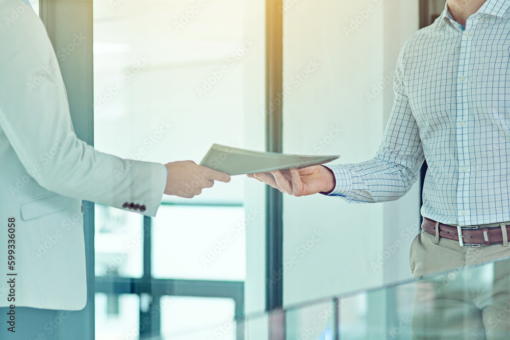 Doing a handover. a businessman handing a document to a colleague.