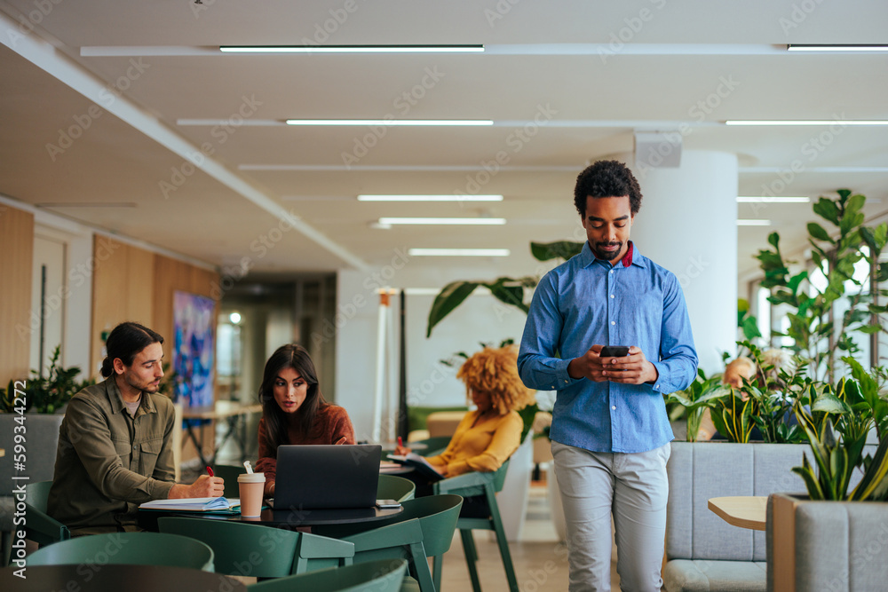 African American man using cellphone at work. African American man using cellphone at work.