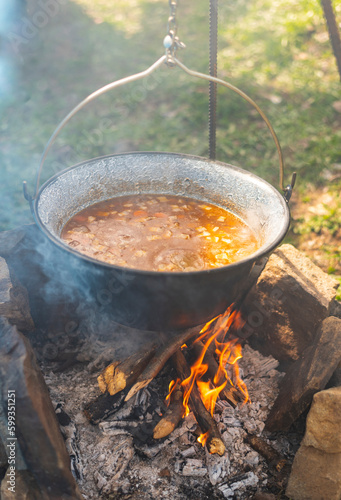 Delicious meal (goulash) made on traditional way in fish pot on camp fire