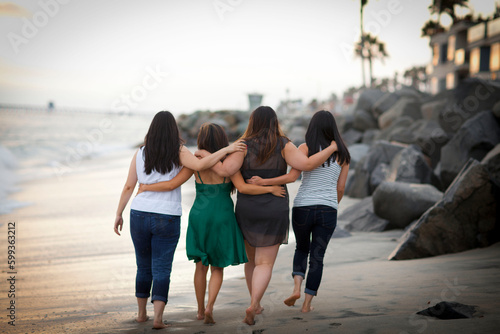 Fotografija Four female friends walking on a beach together