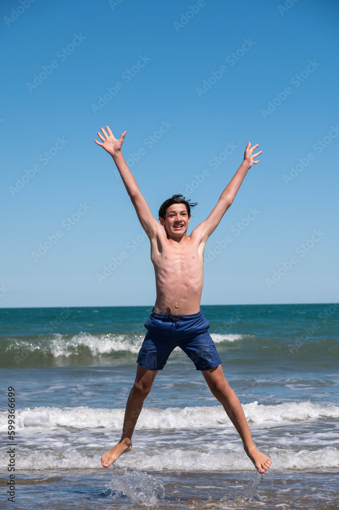 Happy boy performs pirouettes and big jumps on the seashore during his summer vacation on the Atlantic Coast, Las Grutas, Rio Negro, Argentina. Happy boy performs pirouettes and big jumps on the seashore during his summer vacation on the Atlantic Coast, Las Grutas, Rio Negro, Argentina.