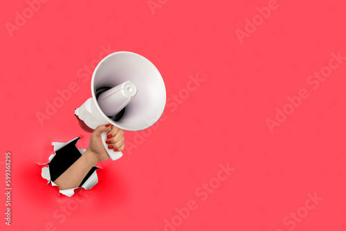 Loudhailer, hand holding megaphone breakthrough paper hole. Announcement, advertising, public hearing concept. Mockup design with loudspeaker, Torn background with blank empty space for copy space