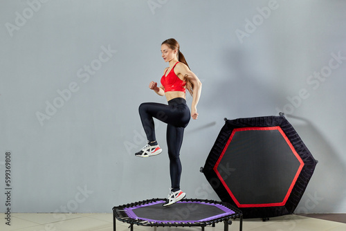 Фотография A young athletic girl does a rebound exercise