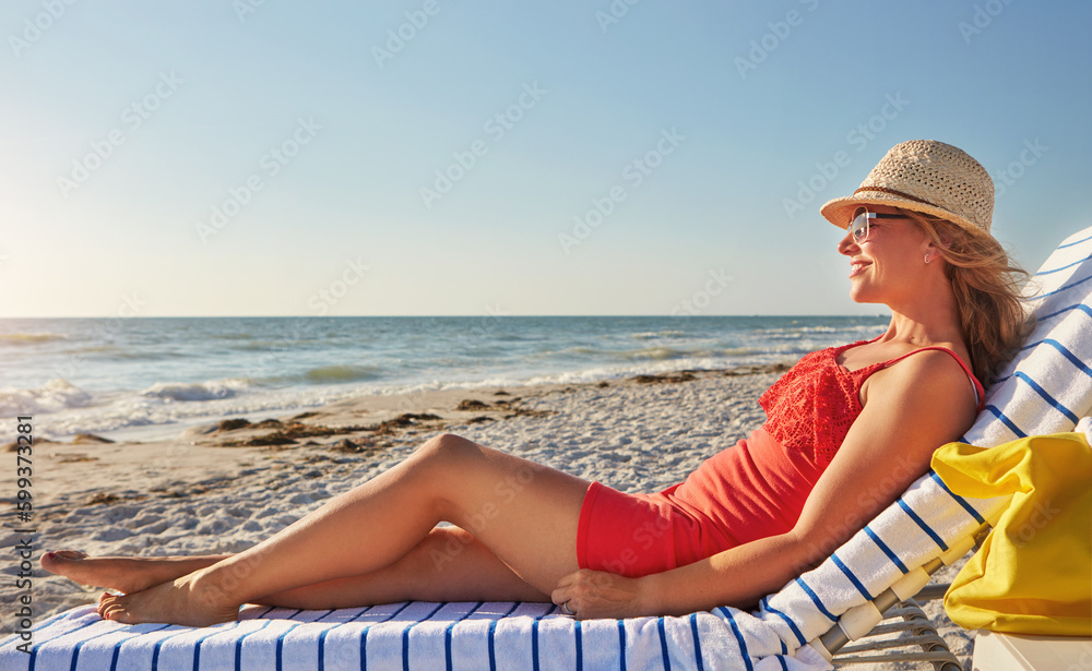 My favorite place on the earth. an attractive woman lying on a lounger at the beach.