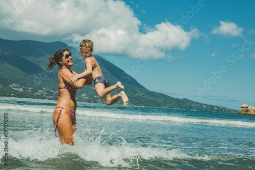 Família brincando no mar da praia no verão