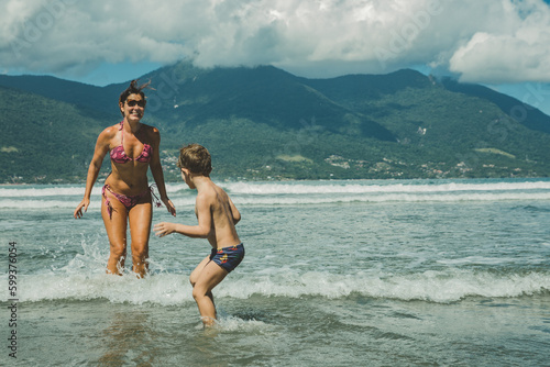 Família brincando no mar da praia no verão photo