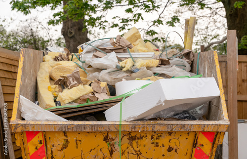 Foto Yellow industrial metal skip full of construction rubbish ready for collection