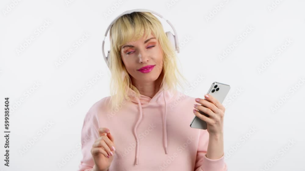 Woman hipster dj, mobile cell phone, dance in headphones for entertainment, streaming service, online radio app. Excited female lady with smartphone listens to music dancing, having fun in club, party Woman hipster dj, mobile cell phone, dance in headphones for entertainment, streaming service, online radio app. Excited female lady with smartphone listens to music dancing, having fun in club, party