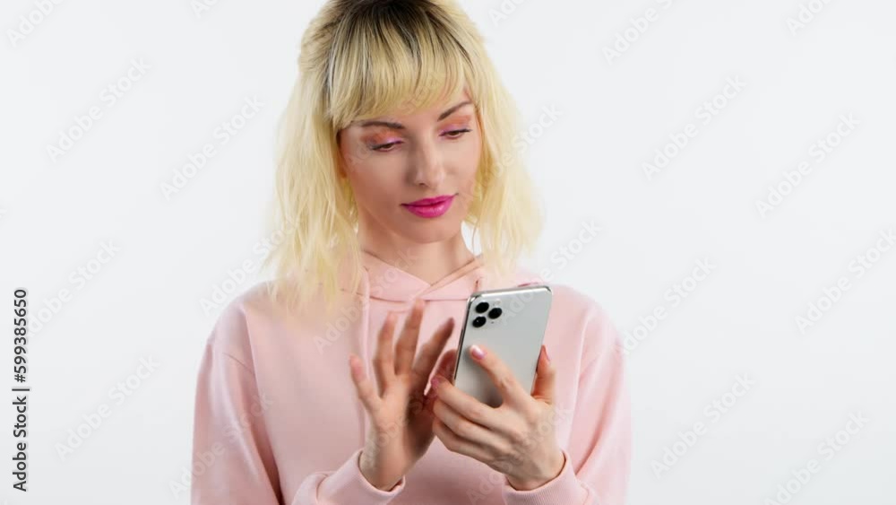 Woman smiling, phone scroll, happiness and swiping on online dating app. Mobile smartphone chat wifi and happy female blonde lady for social media and internet, studio shot isolated on blue background Woman smiling, phone scroll, happiness and swiping on online dating app. Mobile smartphone chat wifi and happy female blonde lady for social media and internet, studio shot isolated on blue background