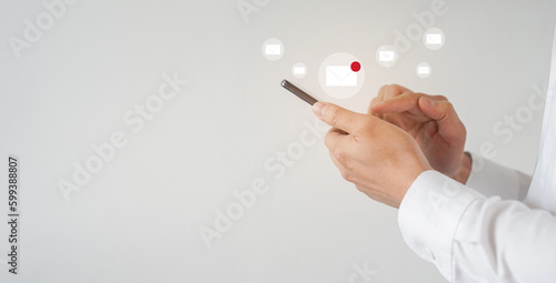 close up businessman hand hold smartphone and using application to check about receiving e-mail marketing or sending to customer in network for technology and modern business concept