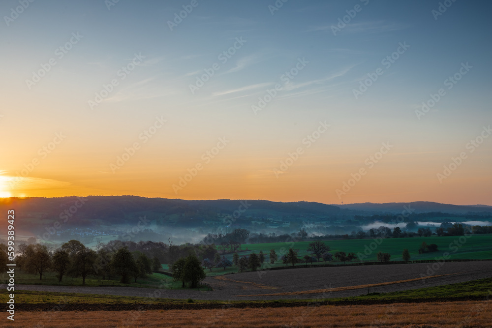 Colourful sunrise on a summer morning with a little fog on the ground and spectacular views over the Dutch hillside near the village of Kuttingen Colourful sunrise on a summer morning with a little fog on the ground and spectacular views over the Dutch hillside near the village of Kuttingen