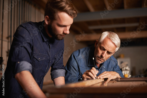 Artisans at work. a father showing his son the tricks of the building trade.