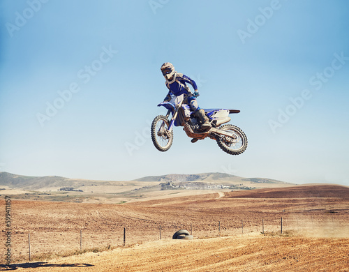 Fototapeta Naklejka Na Ścianę i Meble -  Going over a jump with style. a motocross rider in midair after hitting a jump.