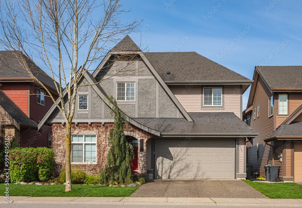 Real Estate Exterior Front House on a sunny day. Big custom made luxury house with driveway to garage