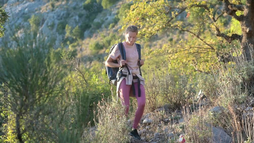 Young woman hiking on mountains in Europe. Concepts of adventure, extreme survival, orienteering. Single travel. Backpacking hike Young woman hiking on mountains in Europe. Concepts of adventure, extreme survival, orienteering. Single travel. Backpacking hike