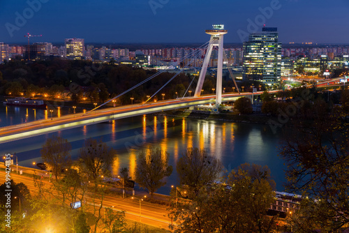 Night view of illuminated Bratislava with futuristic Most SNP over Danube photo