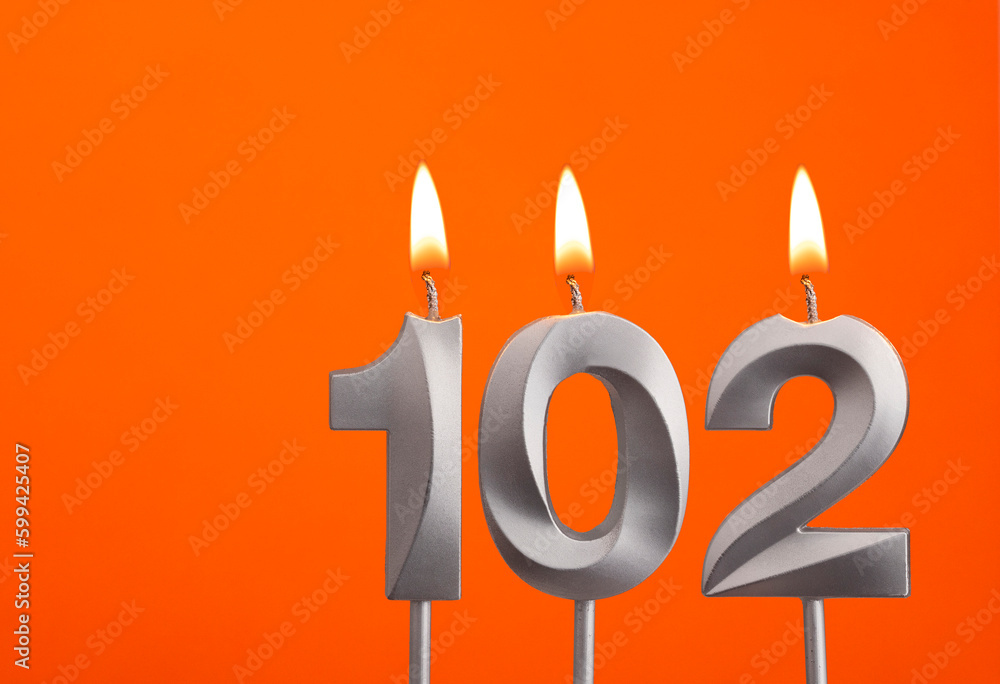 Candle 102 - Silver Anniversary candle on orange background Candle 102 - Silver Anniversary candle on orange background