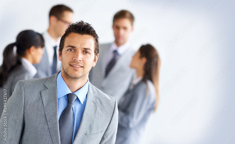 On the outskirts. Portrait of a handsome young businessman with his colleagues standing in the background. On the outskirts. Portrait of a handsome young businessman with his colleagues standing in the background.
