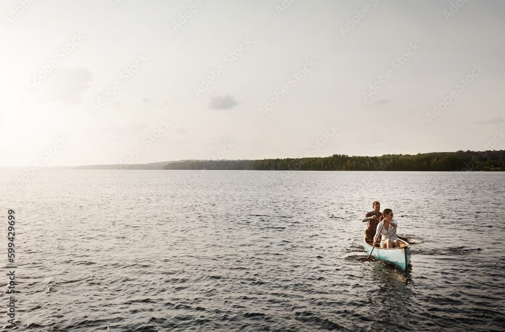 Row together, row further. a young couple going for a canoe ride on the lake.