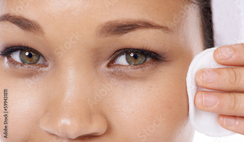 Removing her makeup before bed. Closeup of a young woman cleansing her skin with a cotton pa.