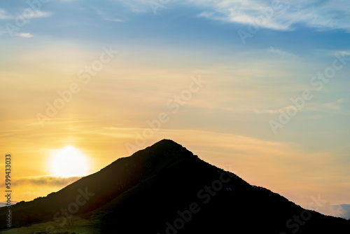 Silhouetted mountain peak at sunset, sunrise