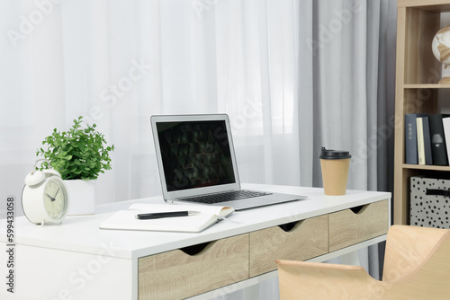 Workplace with modern laptop on desk at home © New Africa